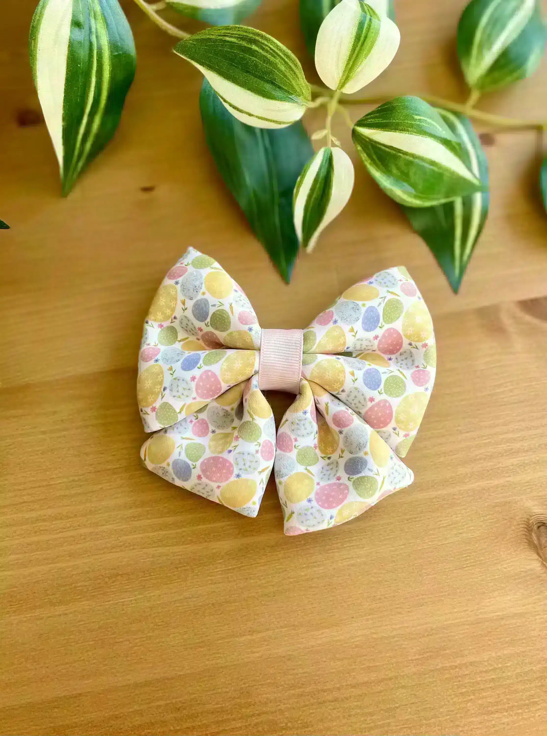 A close-up of a handmade Easter Egg Hair Bow featuring a colorful egg pattern, perfect for girls and women to wear for Easter or spring celebrations.