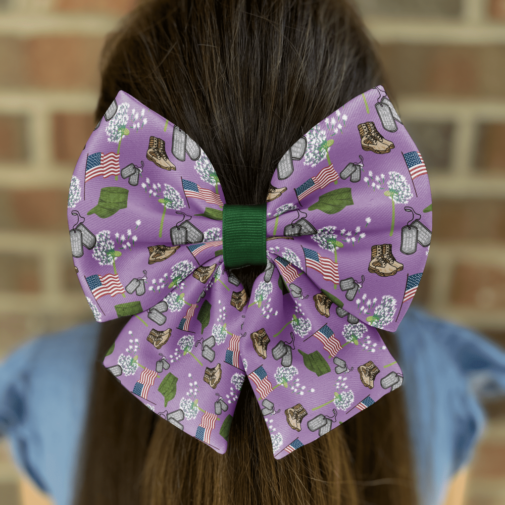 Purple bow with military-themed patterns in hair.