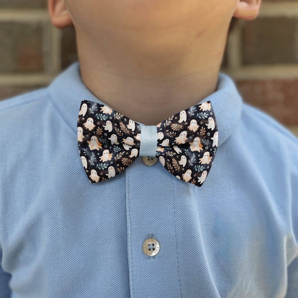 Child wearing Halloween-themed bowtie on blue shirt.