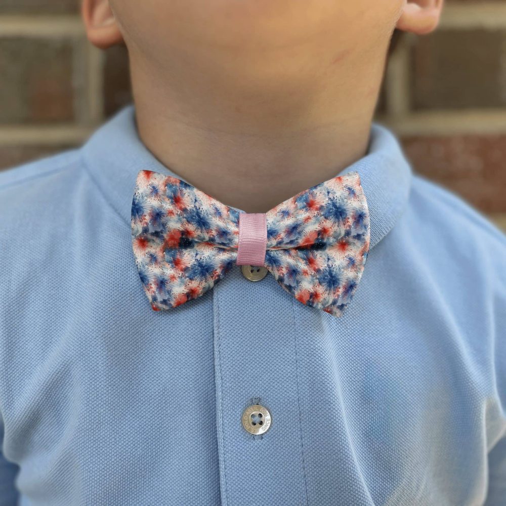 Child in blue shirt with colorful bow tie.