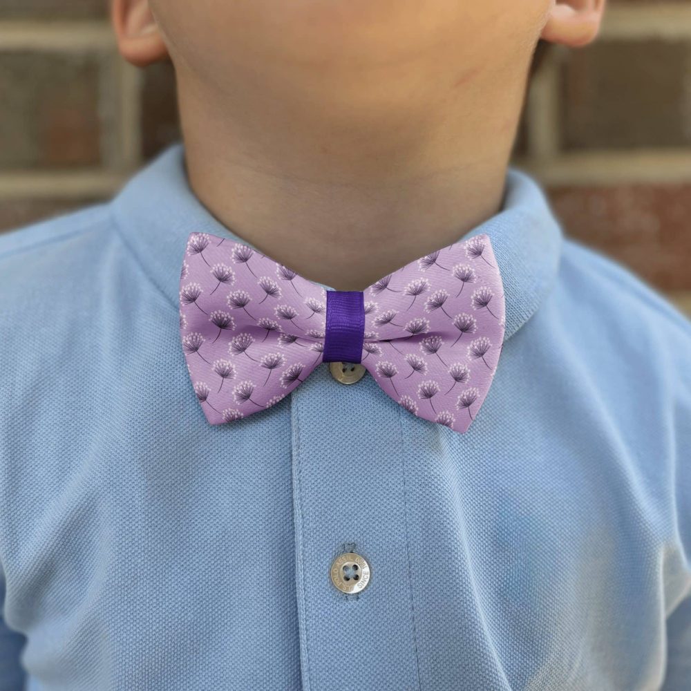 Child in blue shirt with purple bow tie.