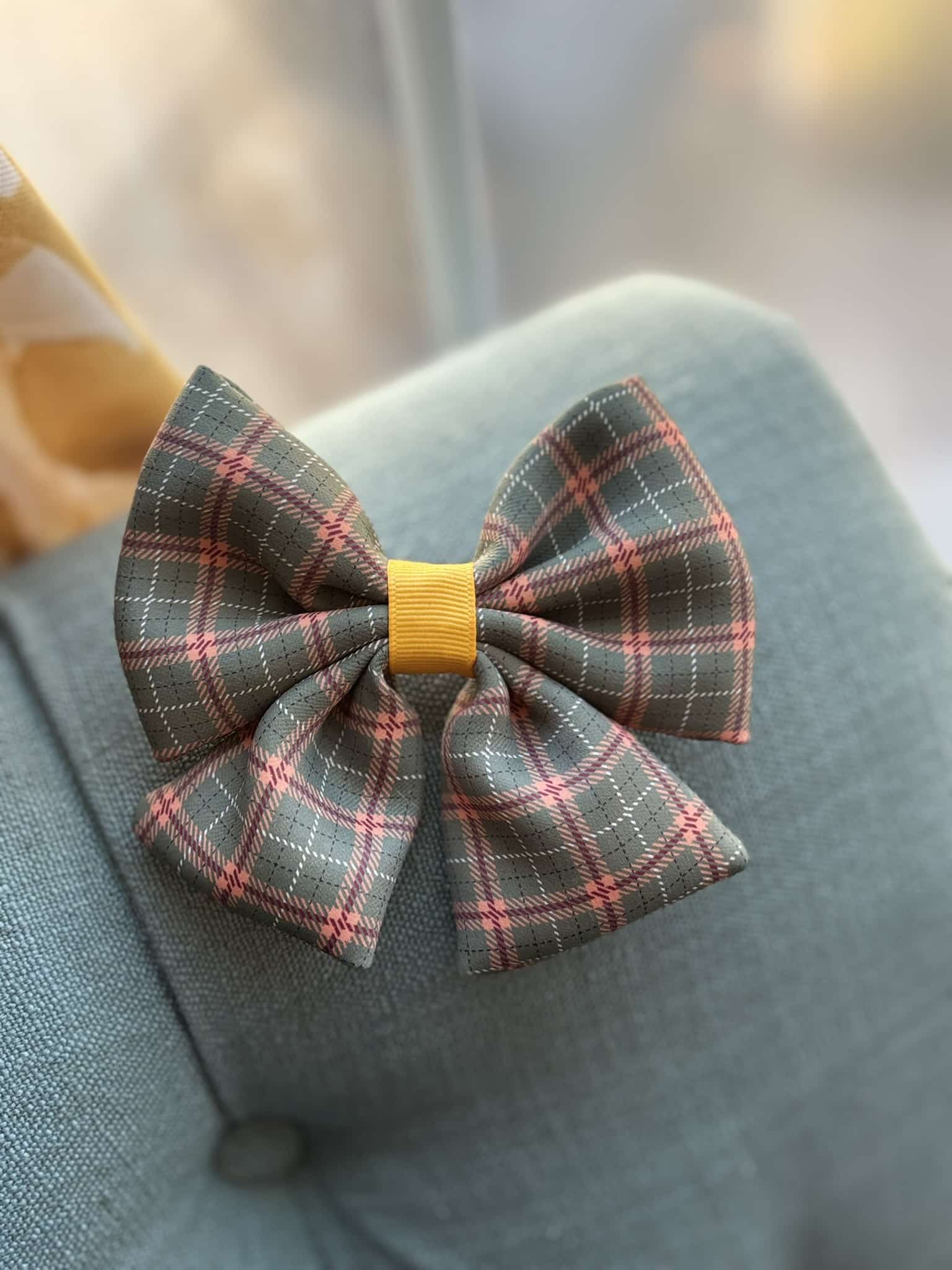 Plaid bow tie on gray fabric chair.