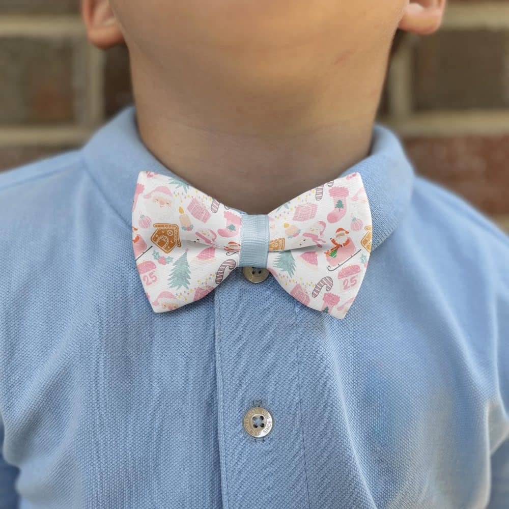 Child wearing festive bow tie on blue shirt.