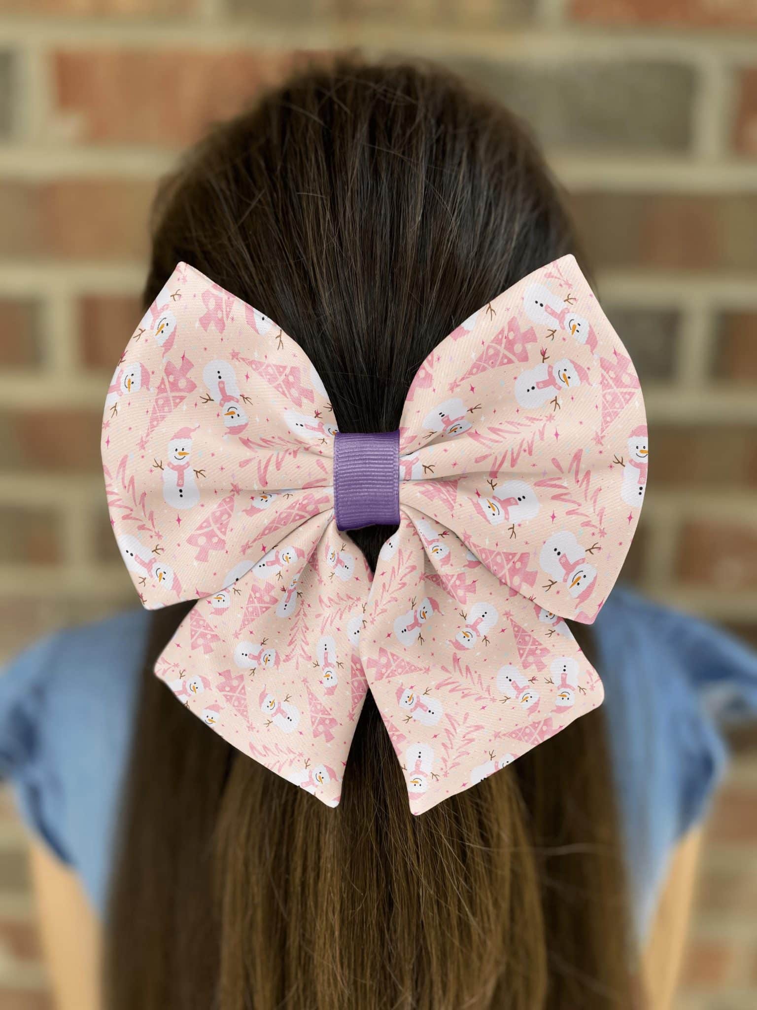 Girl wearing bow with snowman print