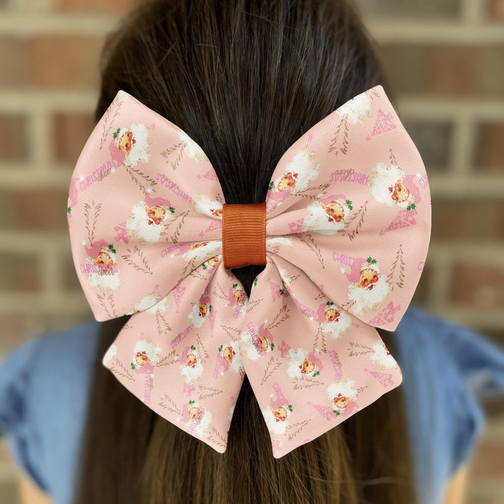 Girl with a large pink Christmas-themed hair bow.