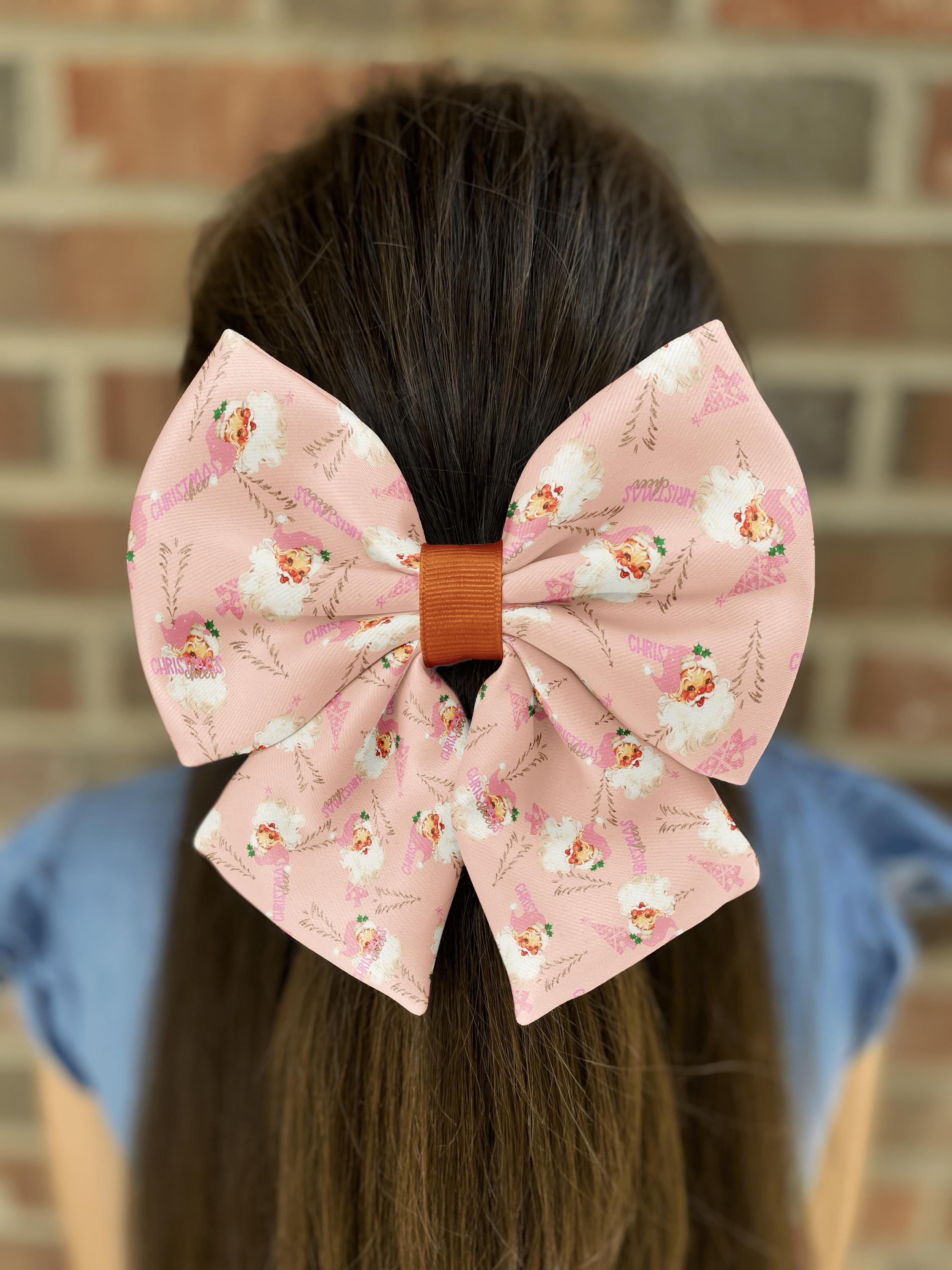 Girl with a large pink Christmas-themed hair bow.